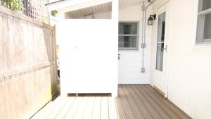 a porch with a white door and a fence at Little Sandpiper in Cape May Point