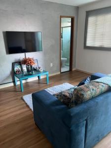 a living room with a blue couch and a table at Riacho Fundo I 201- Boa acomodação com economia in Brasilia