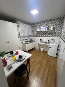 a small kitchen with a table and a counter top at Riacho Fundo I 201- Boa acomodação com economia in Brasilia