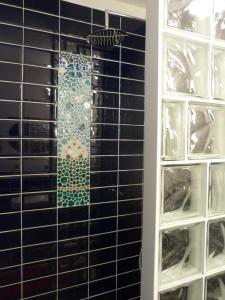a glass tile wall in a room with a shelf at Chez nous Cassis in Cassis