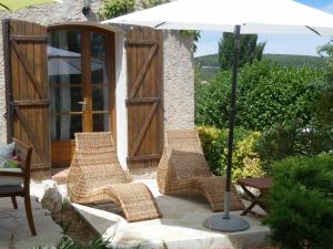 a group of wicker chairs and an umbrella on a patio at Chez nous Cassis in Cassis
