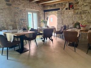 a dining room with tables and chairs and a stone wall at Locanda ai Provveditori in Marano Lagunare