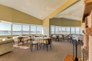 ein Restaurant mit Tischen, Stühlen und Fenstern in der Unterkunft Cunda Hotel in Ayvalık
