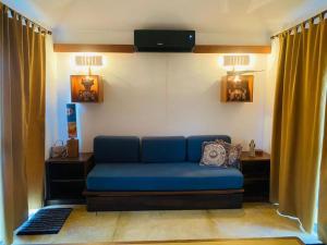 a blue couch in a living room with curtains at La Vaquera - Morrocoy in Sanare