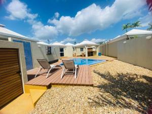 a patio with two chairs and a swimming pool at La Vaquera - Morrocoy in Sanare