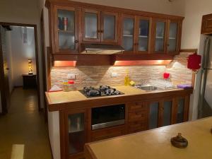 a kitchen with wooden cabinets and a stove top oven at La Vaquera - Morrocoy in Sanare