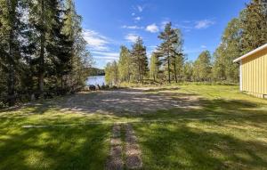 an empty yard with trees and a building and a lake at Räven in Fegen