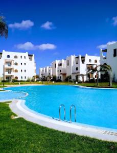 une piscine devant des bâtiments blancs dans l'établissement Séjour calme au Golf & Gardens, à Cabo Negro