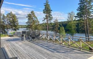 奥尔延Amazing Home In Årjäng With Lake View的一个带桌椅的甲板,俯瞰着湖泊