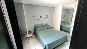 a bedroom with a green bed and a mirror at Apto confortável e aconchegante in Montes Claros