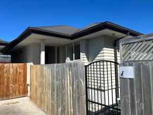 a house with a gate and a fence at Spacious 3 BR house near sumner in Christchurch