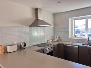 a kitchen with a sink and a stove top oven at Spacious 3 BR house near sumner in Christchurch
