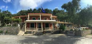 a large house with a flag on top of it at Villa Angelo in Paleokastritsa