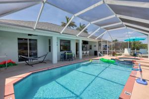 Una gran piscina con dosel sobre una casa. en Luxury Waterfront Vacation Home with Dock and free heated Pool, en Cabo Coral