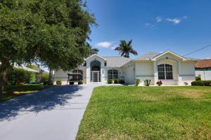 una gran casa blanca con entrada para coches en Luxury Waterfront Vacation Home with Dock and free heated Pool, en Cabo Coral