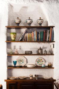 uma prateleira com tigelas e pratos com livros em Casa Graziella al Borgo em Mazzano Romano