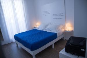 a bedroom with a bed with a blue blanket at Baia Del Sole in Licata