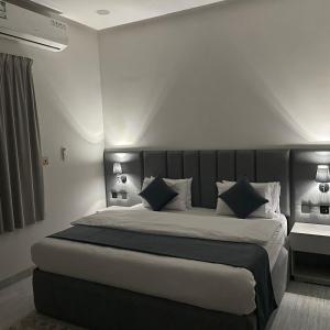 a bedroom with a large bed with blue pillows at النخبة للشقق المخدومة in Hafr Al-Batin +25 photos