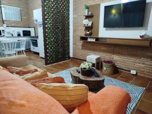 a living room with a couch and a flat screen tv at Chalé Elohim Campos do Jordão in Campos do Jordão +20 photos