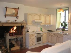 a kitchen with a stove and a fire in the fireplace at Longère 18ème siècle dans le Perche avec WIFI et animaux acceptés - FR-1-497-49 in Pervenchères +14 photos