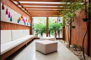 a living room with white furniture and plants at Swan Novo Hamburgo in Novo Hamburgo