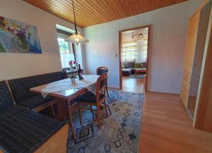 a dining room with a table and chairs and a living room at Landhaus Christina in Rumbach