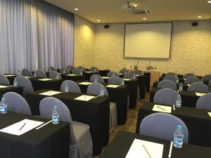 a conference room with tables and chairs and a screen at Prairie Hills Resort in Mu Si
