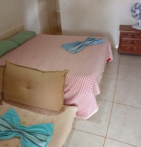 a bedroom with a bed with a red and white blanket at Suite local estratégico wifi5G 12km da pratinha in Água Boa