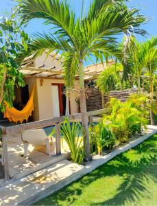 福廷Chalés Refúgio Fortim的一栋门前有棕榈树的房子