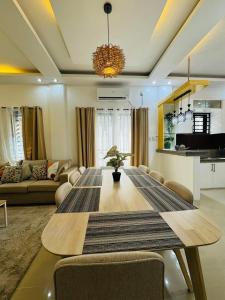 a living room with a large wooden table with chairs at 4 bedroom with big pool villa near clark in Sampong