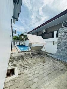 a patio with a bench and a swimming pool at 4 bedroom with big pool villa near clark in Sampong