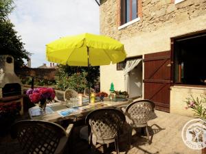 a table with a yellow umbrella on a patio at Charmant gîte avec jardin, WiFi, animaux admis - FR-1-496-90 in Bussières