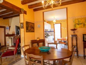 a kitchen and dining room with a wooden table at Maison confortable près de Périgueux avec cheminée, jardin et animaux admis - FR-1-616-10 in Bassillac +5 photos