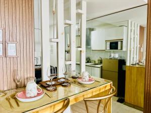 a kitchen with a table with two chairs and wine glasses at Chic Hideaway at Azure North Bali Tower in San Fernando