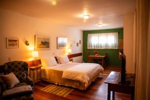 a bedroom with a large bed and a chair at Pousada Barra do Bié in Cunha +52 photos