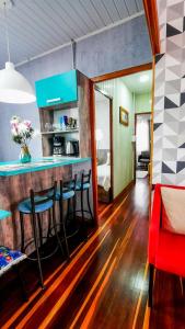 a kitchen with a bar with stools in a room at Hospedagem Don Panizzi in Bento Gonçalves