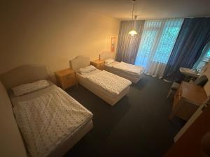 una camera d'albergo con tre letti e una finestra di Turp Residenz a Blomberg