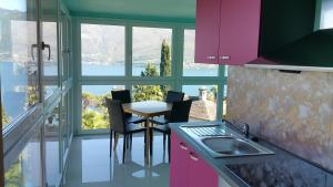 eine Küche mit einem Tisch und Stühlen vor einem Fenster in der Unterkunft Residence Venus Garden in Brissago