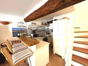 a kitchen with white cabinets and a counter top at Maison de Village Charme Saint-Tropez Centre avec Rooftop - FR-1-728-22 in Saint-Tropez