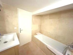 a bathroom with a white tub and a sink at Maison de Village Charme Saint-Tropez Centre avec Rooftop - FR-1-728-22 in Saint-Tropez