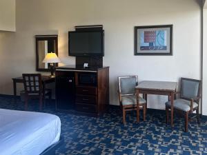 a hotel room with a bed and a tv and a table and chairs at Oceanside, CA – Marina / Camp Pendleton in Oceanside