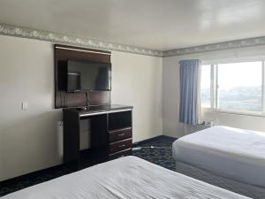 a hotel room with two beds and a flat screen tv at Oceanside, CA – Marina / Camp Pendleton in Oceanside