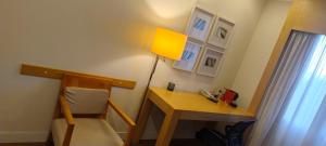 a room with a desk and a lamp and a chair at Flat Aeroporto Congonhas in Sao Paulo