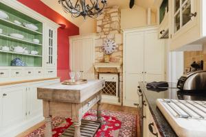 eine Küche mit roten Wänden und weißen Schränken in der Unterkunft Hicks House - Beautiful Cottage in Leysbourne! in Chipping Campden + 21 Fotos
