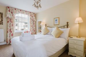 ein Schlafzimmer mit einem weißen Bett und einem Fenster in der Unterkunft Hicks House - Beautiful Cottage in Leysbourne! in Chipping Campden