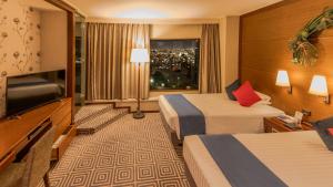 a hotel room with two beds and a flat screen tv at Premier Hotel Nakajima Park Sapporo in Sapporo