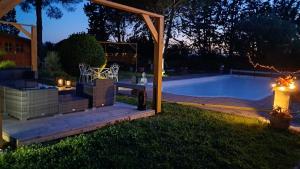 a backyard with a swimming pool at night at Le nid du canal in Pezens