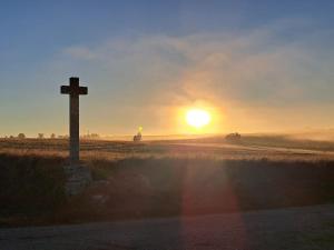 a cross on the side of a field with the sunset at Le nid du canal in Pezens +36 photos