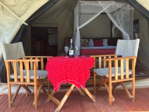 a table with two bottles of wine on it in a tent at Keremasi Camp Lake Natron in Mtowabaga +8 photos