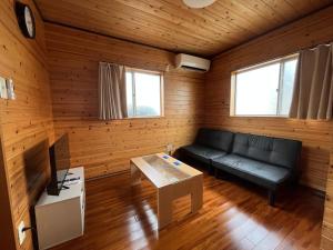 a living room with a couch and a table at 閑静な立地 繁華街とコンビニ バス停徒歩圏内 奄美 Guest House iroha 1日1組 2025年5月 Open Quiet Location Near Downtown One Group Per Day in Amami